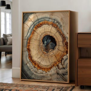 May include: Framed artwork featuring a detailed cross-section of a tree trunk. The artwork showcases concentric rings in shades of brown, beige, and blue, with a dark center. The wooden frame complements the natural tones of the art, creating a rustic aesthetic.