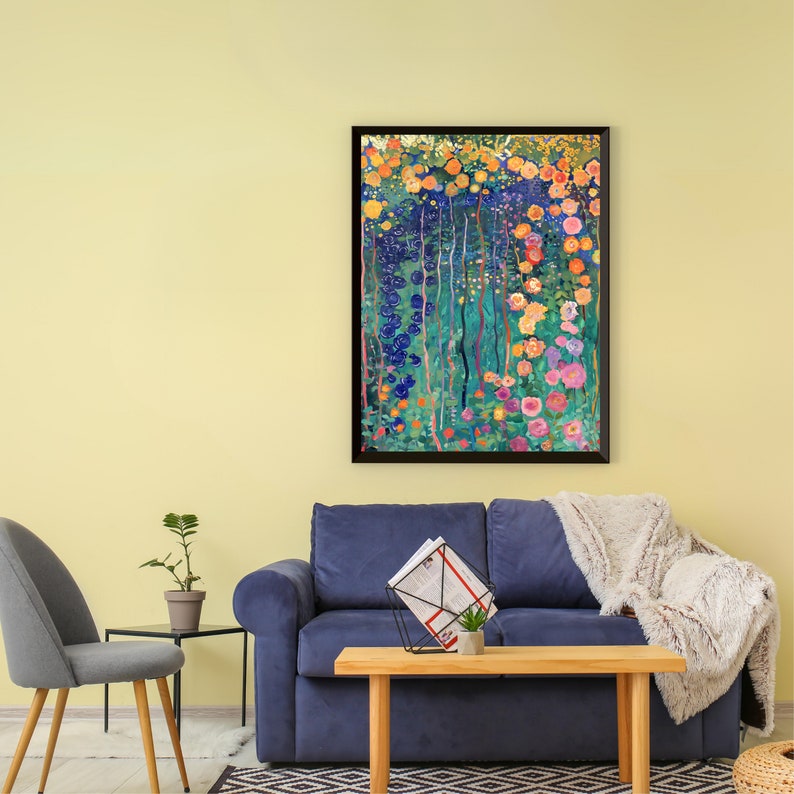 May include: A framed abstract painting of a colorful floral garden with blue, yellow, pink, and green hues. The painting is hanging on a light yellow wall above a blue sofa with a throw blanket.