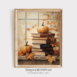 May include: A framed print featuring a stack of books with two pumpkins and autumn leaves. The artwork has a warm color palette of orange, brown, and beige, evoking a cozy fall theme. The text "InspireWithPrint Printable Wall Art" is at the bottom.