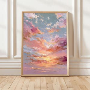 May include: A framed painting depicting a sunset. The artwork showcases a vivid mix of pink, orange, and purple tones in the clouds, set against a light blue sky. The painting is presented in a wooden frame.