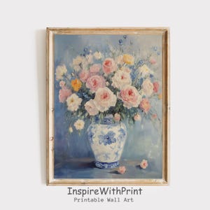 May include: A framed floral still life painting. The artwork features a vase filled with pink, white, and yellow roses and other flowers. The vase is white with blue floral patterns. The background is a soft blue. The text "InspireWithPrint Printable Wall Art" is at the bottom.