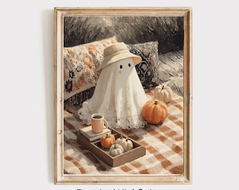 May include: A framed print featuring a whimsical ghost character wearing a hat, surrounded by pumpkins and pillows. The ghost is draped in a white sheet with a lace trim. A wooden tray holds small pumpkins and a mug. The background includes a checkered blanket.