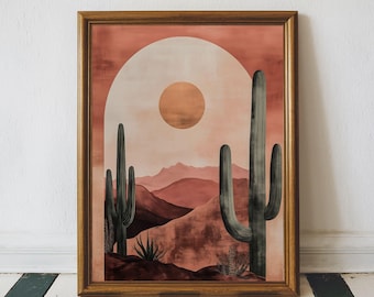 May include: Framed art print featuring a desert landscape with cacti, mountains, and a sun. The artwork is in shades of brown, peach, and gray, with a gold-colored frame. The print evokes a southwestern or desert theme.