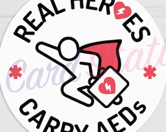 May include: A white, circular sticker with the text "REAL HEROES CARRY AEDs" in black. The design includes a stick figure with a red cape and a heart-shaped AED. The sticker is 2.5" x 2.5".