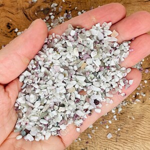 May include: A handful of small, white and pink tumbled stones. The stones are smooth and have a natural, polished look.