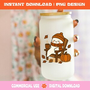 Pode incluir: Uma caneca de vidro fosco em forma de lata com tampa de bambu. A caneca apresenta um fantasma de desenho animado usando chap&eacute;u e cachecol, sentado em uma cadeira de madeira com uma caneca e uma ab&oacute;bora. O texto "INSTANT DOWNLOAD | PNG DESIGN" est&aacute; no topo.
