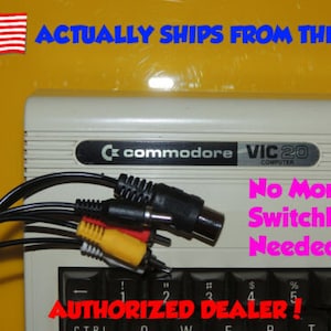 May include: A white Commodore VIC20 computer with a black keyboard and a set of black, yellow, and red RCA cables. The text "No More Switchbox Needed!" is written in pink letters on the computer. The text "AUTHORIZED DEALER!" is written in black letters on the bottom of the image.