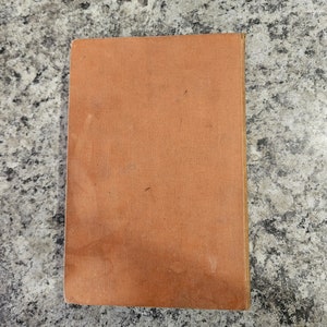 Puede incluir: Una cubierta de libro naranja lisa con una superficie ligeramente texturizada.