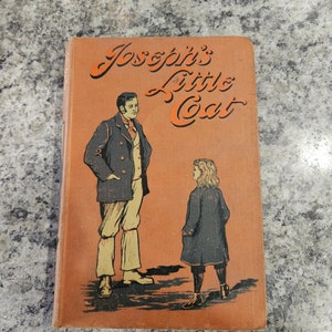 Puede incluir: Un libro naranja con el t&iacute;tulo "Joseph's Little Coat" en letras cursivas negras. La portada presenta una ilustraci&oacute;n de un hombre y un ni&ntilde;o con ropa de &eacute;poca.