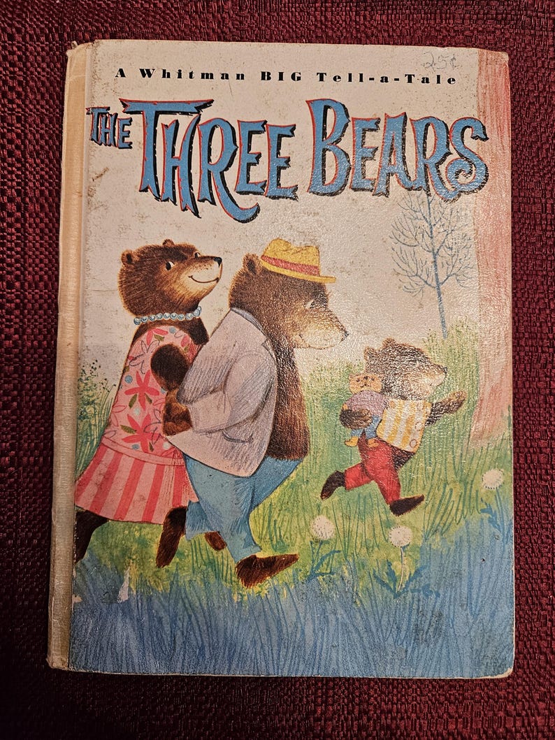 Op de afbeelding: Vintage kinderboek getiteld "The Three Bears" van Whitman. De omslag toont een illustratie van drie beren in een kleurrijke buitensc&egrave;ne. De titel staat in grote, blauwe, gestileerde letters.