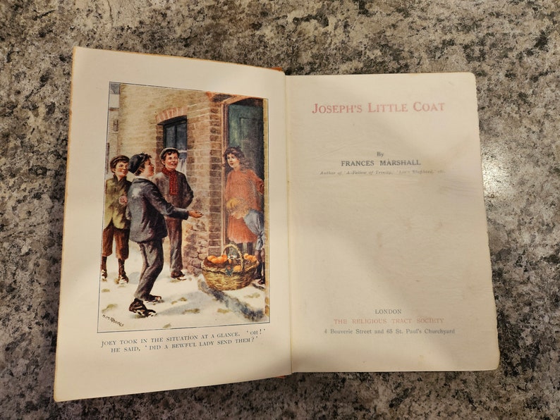 Puede incluir: Un libro abierto con una ilustraci&oacute;n colorida de tres ni&ntilde;os de pie frente a una puerta. El libro se titula "Joseph's Little Coat" de Frances Marshall. El texto en la p&aacute;gina dice "Joey capt&oacute; la situaci&oacute;n de un vistazo. "&iexcl;Oh!" dijo, "&iquest;Una hermosa dama los envi&oacute;?"