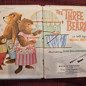 Op de afbeelding: Illustratie uit het kinderboek 'De Drie Beren'. De afbeelding toont drie beren, met de moederbeer die soep serveert. De titel is oranje. Ge&iuml;llustreerd door June Goldsborough.