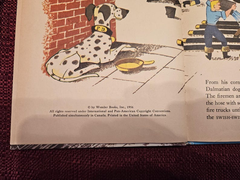 May include: A black and white Dalmatian dog wearing a red collar with the letters "F.D." on it. The dog is lying down on a brick sidewalk with a yellow metal bowl next to it. The text "&copy; by Wonder Books, Inc., 1956" is at the bottom of the page.