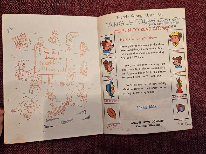 May include: An open book with a red inscription that says "This Book Belongs to Scott Fannel". The book is titled "Tangleton Tales" and has illustrations of animals and a football.