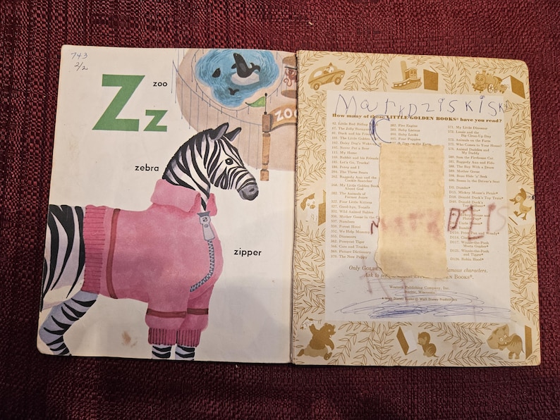 May include: A vintage children's book with a zebra wearing a pink jacket on the cover. The book is titled "Little Golden Books" and has a list of other books on the back cover.