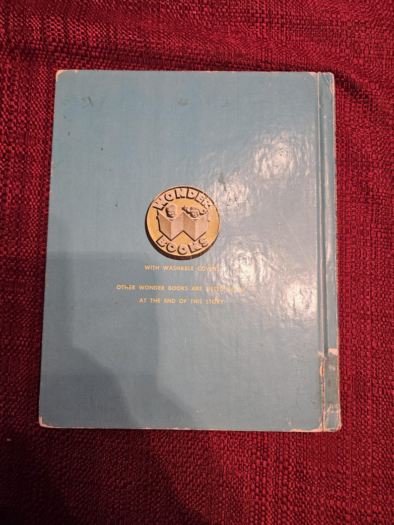 May include: Blue book with a gold Wonder Books logo featuring two children reading. The text on the back cover reads "With washable covers. Other Wonder Books are listed at the end of this story."