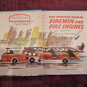 May include: A vintage children's book titled "The Wonder Book of Firemen and Fire Engines" by Lisa Peters, illustrated by William Weiner. The cover features a red fire engine with firefighters driving through a city.