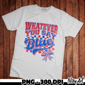 May include: White t-shirt with red, white and blue text that says "Whatever You Say Blue" with a red, white and blue bow.
