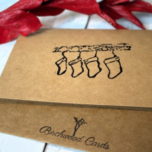 Carte de voeux sculptée et estampée à la main avec des bas de Noël