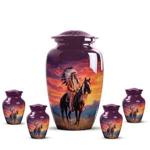 May include: A set of purple cremation urns depicting a Native American chief on horseback against a sunset backdrop. The main urn is flanked by smaller versions, all with the same artwork. The design uses warm colours and detailed illustrations.