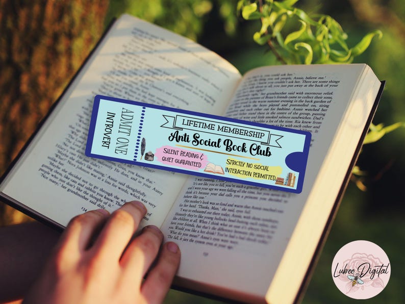 May include: A blue and white ticket-style bookmark with the text "Anti Social Book Club" and "Silent Reading & Quiet Guaranteed". The bookmark is placed on an open book.