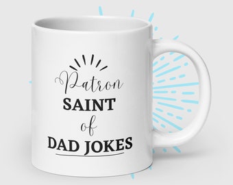 May include: White ceramic mug with black text that reads "Patron Saint of Dad Jokes".