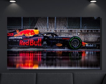 以下が含まれることがあります： レッドブルのブランドとホンダエンジンを搭載した黒いフォーミュラワンレーシングカーが、濡れたトラックを走行しています。車はトラックの水に反射しています。