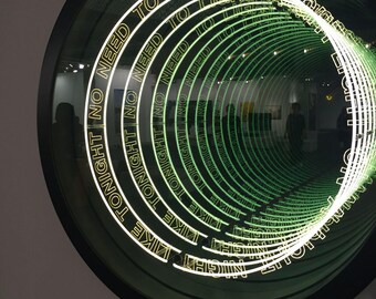 May include: A circular infinity mirror featuring a black frame and internal neon-style lighting. The text NO NEED TO LIGHT A NIGHT LIKE TONIGHT is repeated in a concentric pattern, creating a tunnel effect with glowing green and white light.