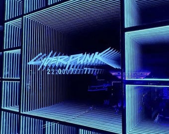 May include: A light installation featuring a repeating square tunnel effect illuminated in bright blue neon. The text Cyberpunk is displayed in the center, followed by the numerical sequence 2 200007777777, creating a deep perspective effect.