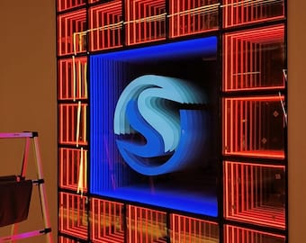 May include: A wall-mounted infinity mirror display featuring a grid of red neon-style square frames surrounding a central blue illuminated letter S. The central S appears to recede into a deep tunnel effect created by layered blue light reflections.