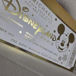 May include: A gold and white Disneyland Paris ticket with the name "MICHAEL" and the date "OCTOBER 2025". The ticket features the Disneyland logo, Mickey Mouse, and the phrase "THE MOST MAGICAL PLACE ON EARTH."