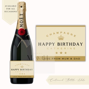 May include: A gold and black champagne bottle label with the text "Champagne Happy Birthday Catherine Love from Mum & Dad".