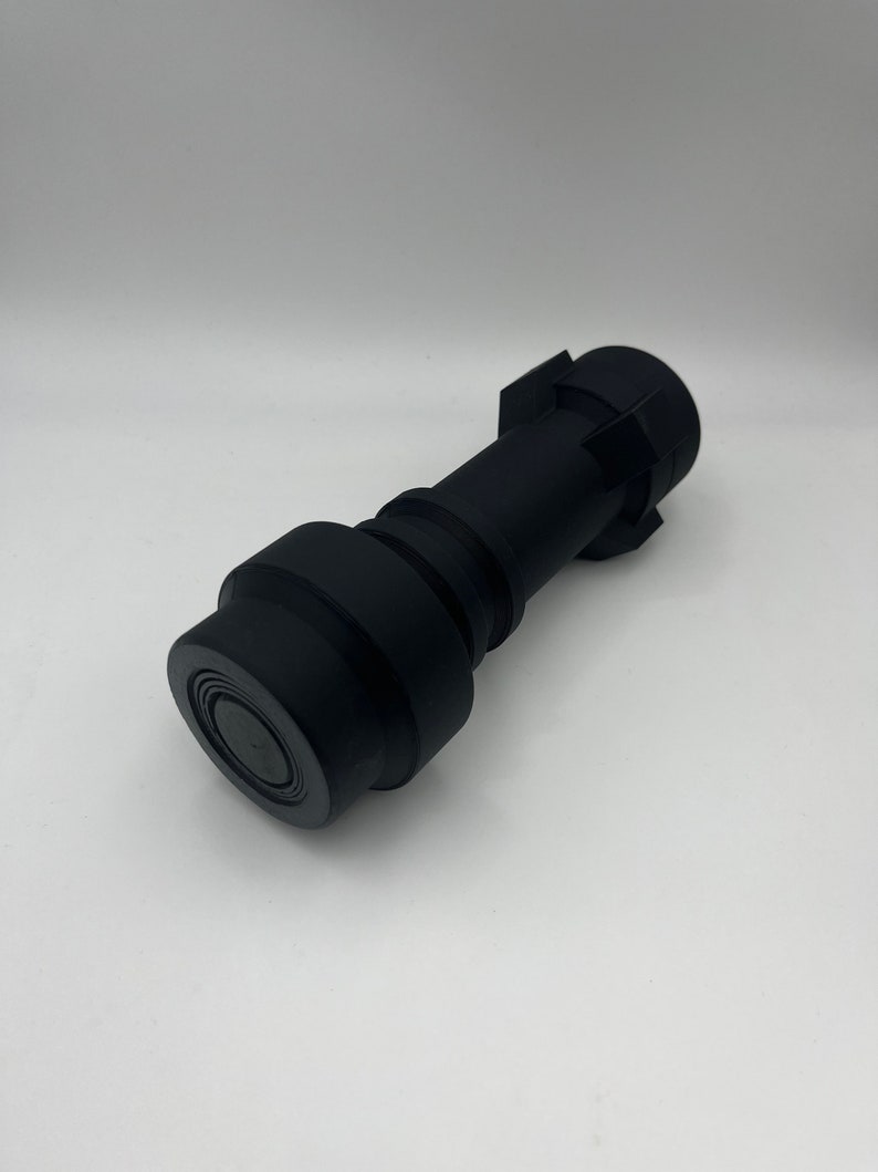 May include: A black plastic connector with a round end and a hexagonal end.