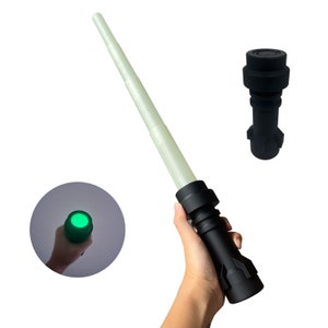 May include: A black lightsaber toy with a green light at the end. The lightsaber is made of plastic and has a telescoping handle.