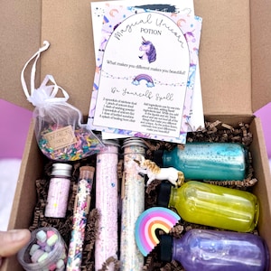 May include: A whimsical unicorn potion kit in a cardboard box. The kit includes small bottles and vials filled with colorful powders and liquids, a rainbow, a unicorn figurine, and a card that reads "Magical Unicorn Potion".