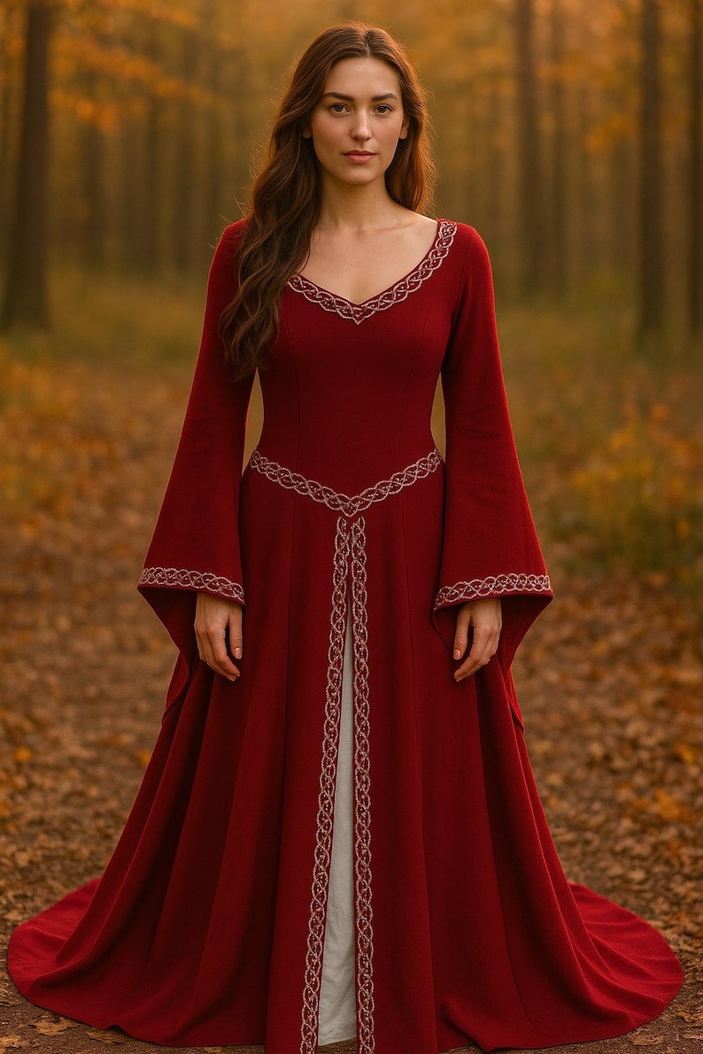 May include: A full-length, crimson dress with long, flared sleeves and a V-shaped neckline. The dress is adorned with gold-coloured embroidery around the neckline, sleeves, and waist. The dress is worn in a forest.