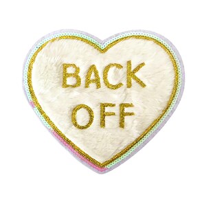 May include: White heart-shaped patch with a gold embroidered message that says "BACK OFF" surrounded by a pink and green border.