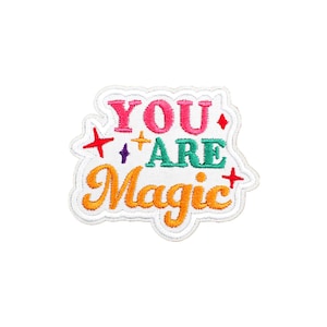 Puede incluir: Parche blanco bordado con el texto "YOU ARE Magic" en letras de colores. El texto está rodeado de pequeñas estrellas.