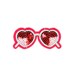 May include: A pair of heart-shaped sunglasses with red and white sequins. The sunglasses are outlined in pink.