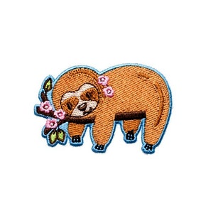 May include: Embroidered iron-on patch featuring a brown sloth with pink flowers on a blue branch.
