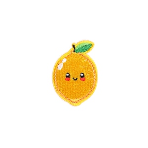 May include: A yellow embroidered iron-on patch of a smiling orange with a green leaf.