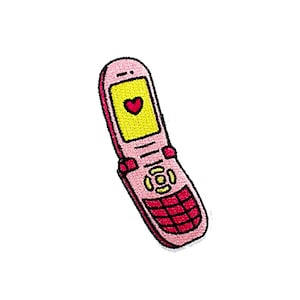 Könnte beinhalten: Ein pinkfarbenes Klapphandy mit gelbem Bildschirm und einem roten Herz-Symbol. Das Telefon hat einen schwarzen Rahmen und eine rote Tastatur.
