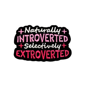 Op de afbeelding: Een zwarte patch met de geborduurde tekst "+ Naturally + INTROVERTED + Selectively + EXTROVERTED" in wit en roze. De patch heeft een zwarte rand en staat op een witte achtergrond.