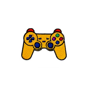 Puede incluir: Un mando de videojuegos amarillo con botones rojos, azules y verdes. El mando es un accesorio popular para las consolas de videojuegos.