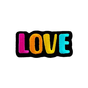 May include: A black felt patch with the word "LOVE" embroidered in pink, orange, yellow, and blue.