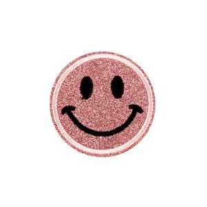 Könnte beinhalten: Ein rosafarbener Glitzer-Smiley-Patch mit weißem Rand.