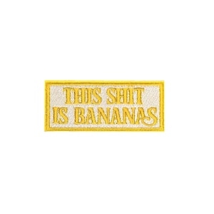 Peut inclure: Écusson brodé rectangulaire avec l'inscription "THIS SHIT IS BANANAS" en fil jaune sur fond blanc, bordé de jaune. Le patch est conçu pour être cousu ou repassé sur des vêtements ou du tissu.