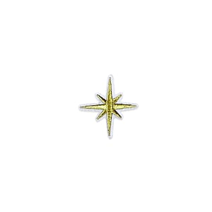 May include: A gold star-shaped patch with eight points, outlined in white. The star has a metallic gold center and a white border. The patch is likely for decorative purposes, such as on clothing or accessories.