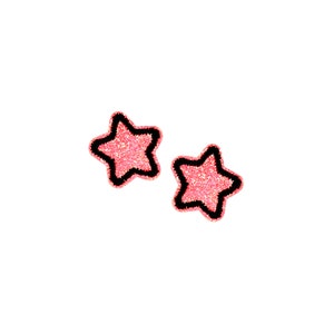May include: Two pink glitter star-shaped stickers with black outlines.