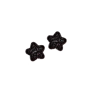 May include: A pair of black star-shaped earrings with glitter.